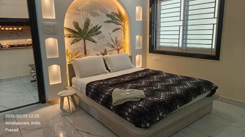 a bedroom with a bed with a painting on the wall at Suneetha Presidency in Amalāpuram