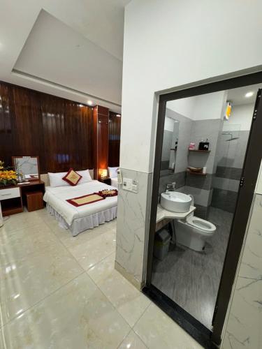a bedroom with a bed and a sink and a toilet at Sapphire HOTEL HUE in Hue