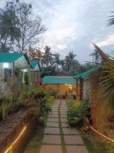 a garden with a walkway next to a building at Bhakti Yoga Ashram in Canacona