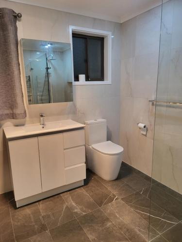 a bathroom with a toilet and a sink and a shower at Treasure in Karabah in Queanbeyan