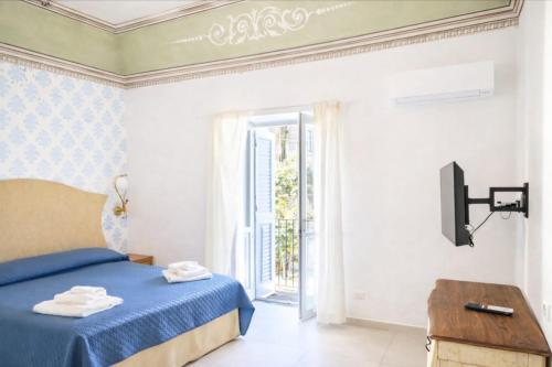 a bedroom with a blue bed and a sliding glass door at Corso Vittorio Elegant Suites Lipari in Lipari