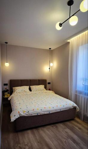 a bedroom with a large bed with lights on it at Geese apt in Kremenchuk