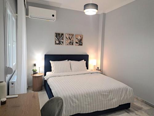 a bedroom with a bed with a blue headboard at Twins Apartments 2 in Serres