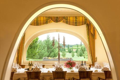 uma sala de jantar com uma grande janela e uma mesa em La Tavernetta Al Castello em Capriva del Friuli