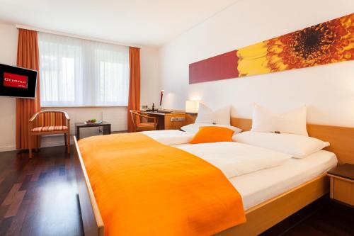 ein Hotelzimmer mit einem großen Bett und einem TV in der Unterkunft Hotel Germania in Bregenz