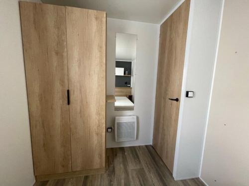 a small room with a wooden cabinet and a sink at CAMPING Les EMBRUNS - 4 ETOILES in Lège-Cap-Ferret
