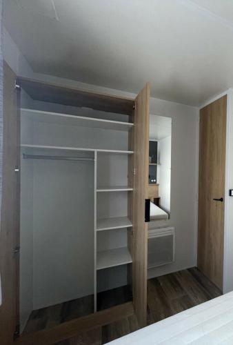 a room with a closet with wooden shelves at CAMPING Les EMBRUNS - 4 ETOILES in Lège-Cap-Ferret