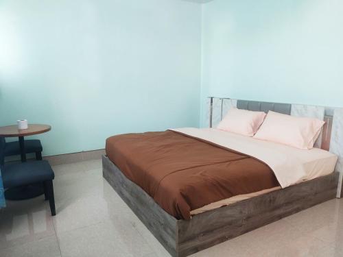 a bedroom with a bed and a table with a chair at 55 Hostel Soi Phetkasem 51 in Ban Tambon Bang Khae