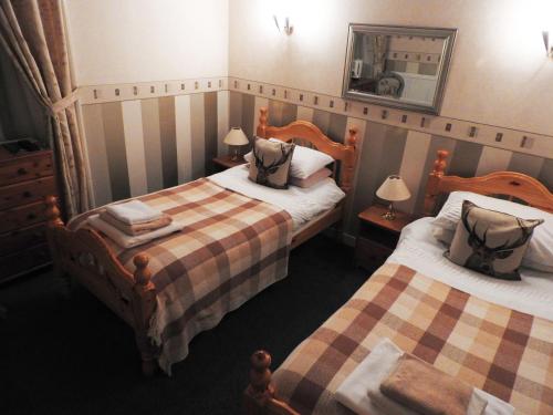 a hotel room with two beds and a mirror at The Stag Head Hotel in Edinburgh