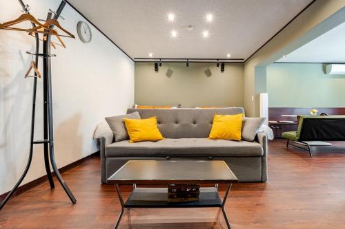 a living room with a gray couch and yellow pillows at Shibuya 10 min Walk Theater & Garden Stay Max 6ppl in Tokyo