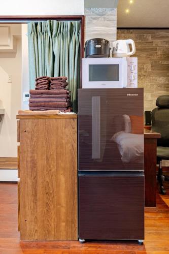 a microwave oven sitting next to a counter with towels at Shibuya 10 min Walk Theater & Garden Stay Max 6ppl in Tokyo