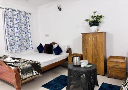 a bedroom with a bed and a chair and a table at The Wildcamp - Coorg in Kushālnagar