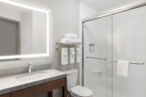 a bathroom with a toilet and a sink and a shower at Candlewood Suites Yuma by IHG in Yuma
