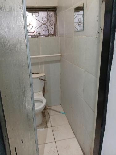 a bathroom with a toilet and a window at 3 bedroom self catering in Rustenburg