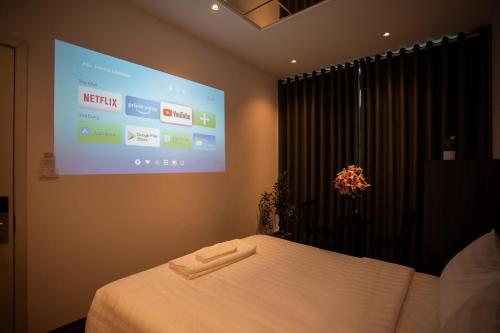 a bedroom with a bed with a projection screen at Luma Boutique Hotel in Hanoi