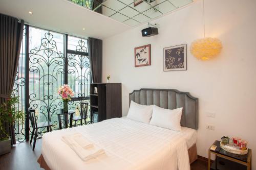 a bedroom with a bed and a balcony at Luma Boutique Hotel in Hanoi