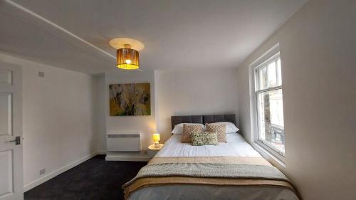 a bedroom with a large bed and a window at 1A Central Bedford Apartment in Bedford