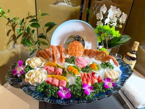a platter of food on a table with flowers at Tsuru Yoshikawa Onsen in Manazuru