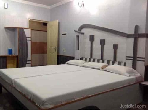 a bedroom with a large white bed in a room at Le Palace in Gūduvāncheri