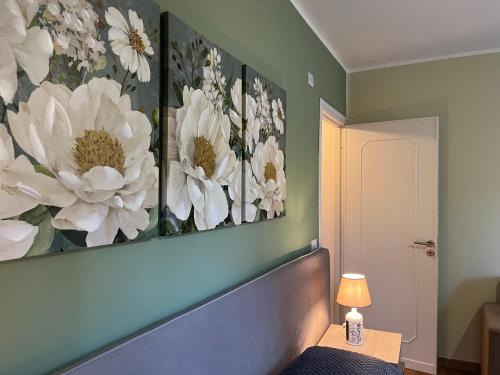 a bedroom with three paintings of flowers on the wall at A Casuzza in Pollina