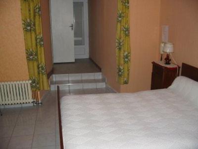 a bedroom with a bed and a hallway with a staircase at Auberge du Meygal in Champclause