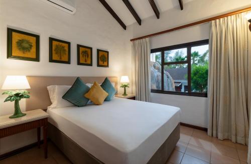 a bedroom with a large bed and a window at Eden's Holiday Villas in Mahe