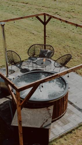 a hot tub with a table and chairs on a patio at oto.domki in Rokiciny Podhalanskie