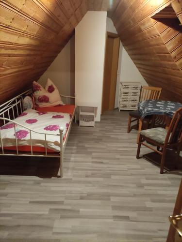a attic room with a bed and a chair at Ferienwohnung Mandy in Morsleben