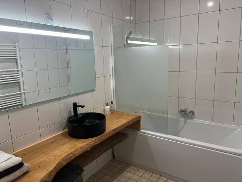 a bathroom with a sink and a bath tub at Au point du jour Ch2 in Récourt-le-Creux