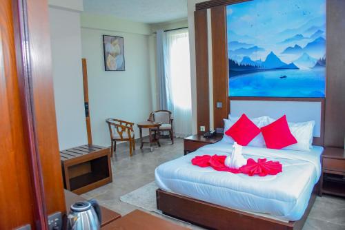 a hotel room with a bed with red pillows at The Residence Hotel Dodoma in Dodoma