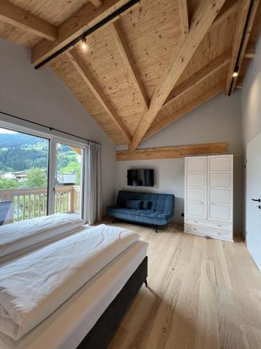 a bedroom with a large bed and a large window at Villa Chalet Schlossalm bis 9 Personen in Bad Hofgastein
