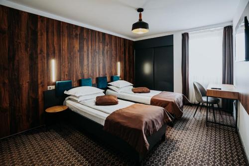 a hotel room with two beds and a desk at Pension Belascu in Sibiu