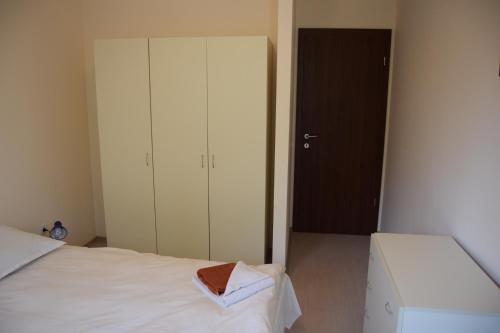 a small bedroom with a white bed and a closet at Borovets Holiday Apartments - Different Locations in Borovets in Borovets
