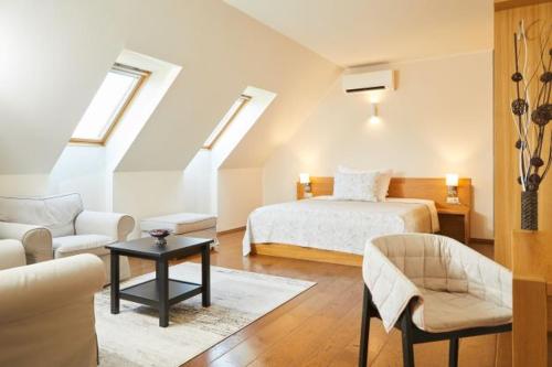 a bedroom with a bed and a living room at Villa Tolnay Vendégház in Gyulakeszi