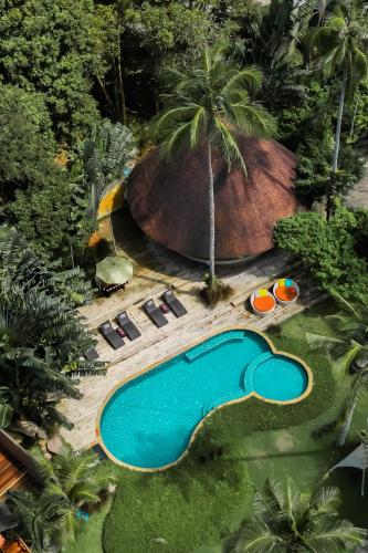 an overhead view of a swimming pool with chairs and a slide at Tolani Resort Koh Kood in Ko Kood