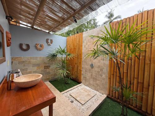 a bathroom with a sink and a wooden fence at Gili Tenda in Gili Trawangan