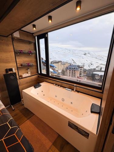 a large tub in a room with a large window at SnowGranada Love Snow Jacuzzi in Sierra Nevada