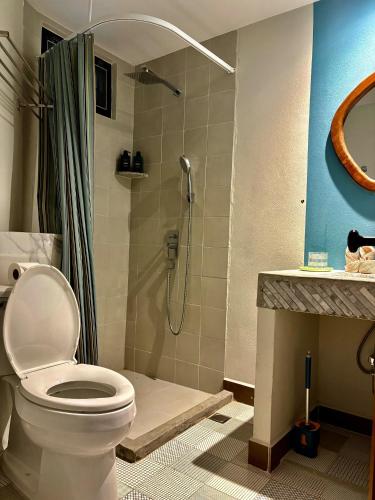 a bathroom with a toilet and a shower at Mersey Residence Koh Samui in Lamai