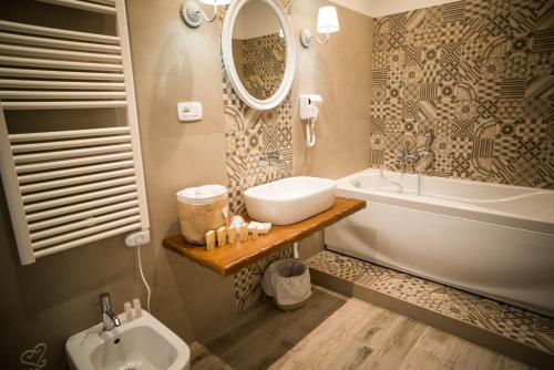 La salle de bains est pourvue d'un lavabo, d'une baignoire et d'un miroir. dans l'établissement Romantica Salerno, à Salerne