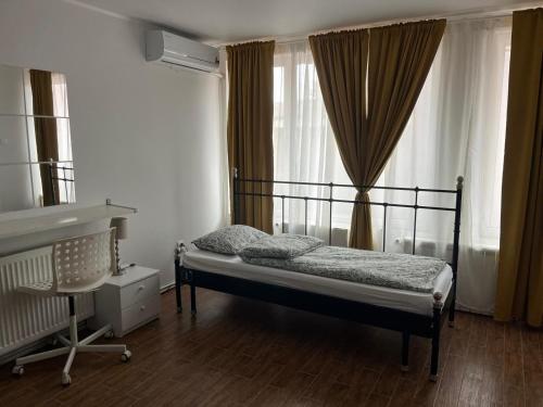 a bedroom with a bed and a desk and a window at Casa Raicu in Ploieşti
