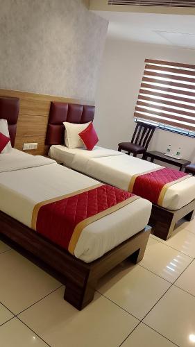 two beds in a hotel room with at Mayuri Residency BTM Layout in Bangalore