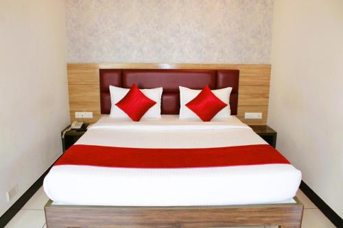 a bedroom with a large bed with red pillows at Mayuri Residency BTM Layout in Bangalore