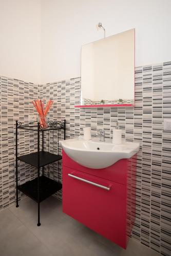 a bathroom with a red sink and a mirror at B&B Gli Alberetti in Loreto
