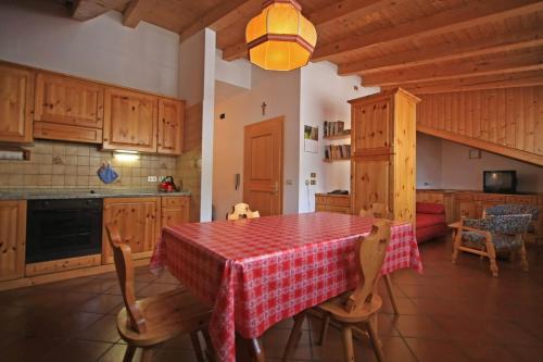 a kitchen with a table with a red and white table cloth at Tony Sport appartamenti in Vigo di Fassa