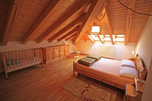 a large room with a bed and a crib at Tony Sport appartamenti in Vigo di Fassa