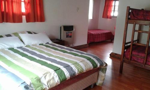 a bedroom with a bed and a ladder and red curtains at La Protegida in El Chalten