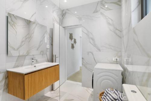 a white bathroom with a toilet and a sink at The Palms Seaside - Kolymvari in Kolymvari
