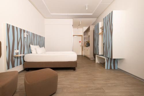 a bedroom with a bed and a chair in it at east Apart in Erlangen