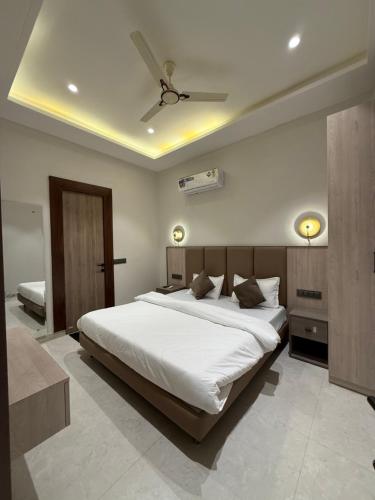a bedroom with a large white bed and a ceiling at Hotel sky inn in Jalandhar