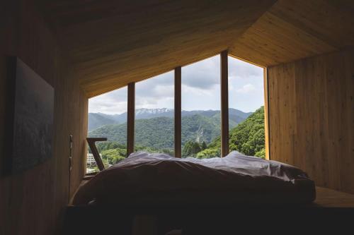 a bed in a room with a large window at Earthboat Minakami Fujiwara in Sudagai